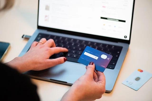 Una persona usa una carta bancaria per un acquisto al computer
