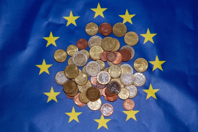 Monete in euro fotografate su una bandiera europea nel novembre 2023