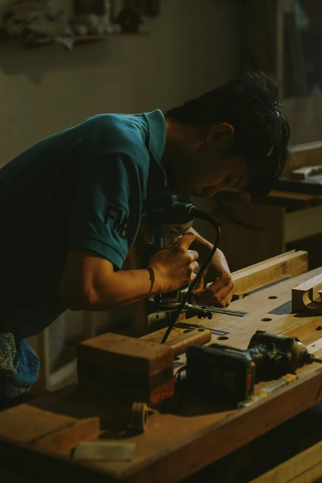 Un falegname lavora il legno con una fresatrice nel laboratorio