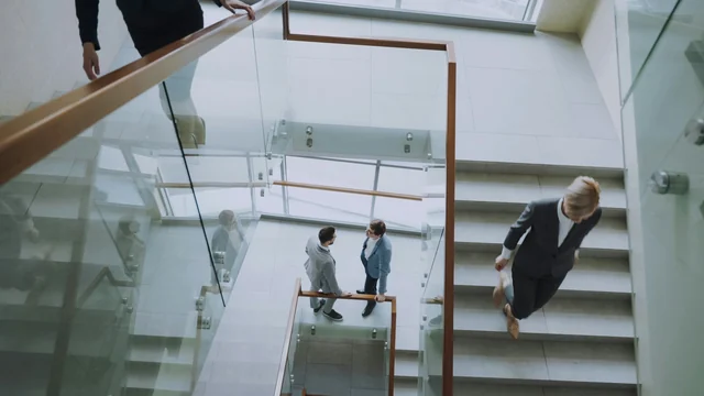 Professionisti si incontrano sulle scale di un moderno centro uffici