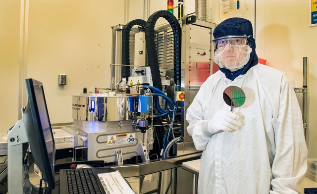 L’ingegnere Richard Kasica mostra un wafer nel laboratorio del Center for Nanoscale Science and Technology del NIST, accanto a un impianto di deposizione chimica da vapore assistita da plasma